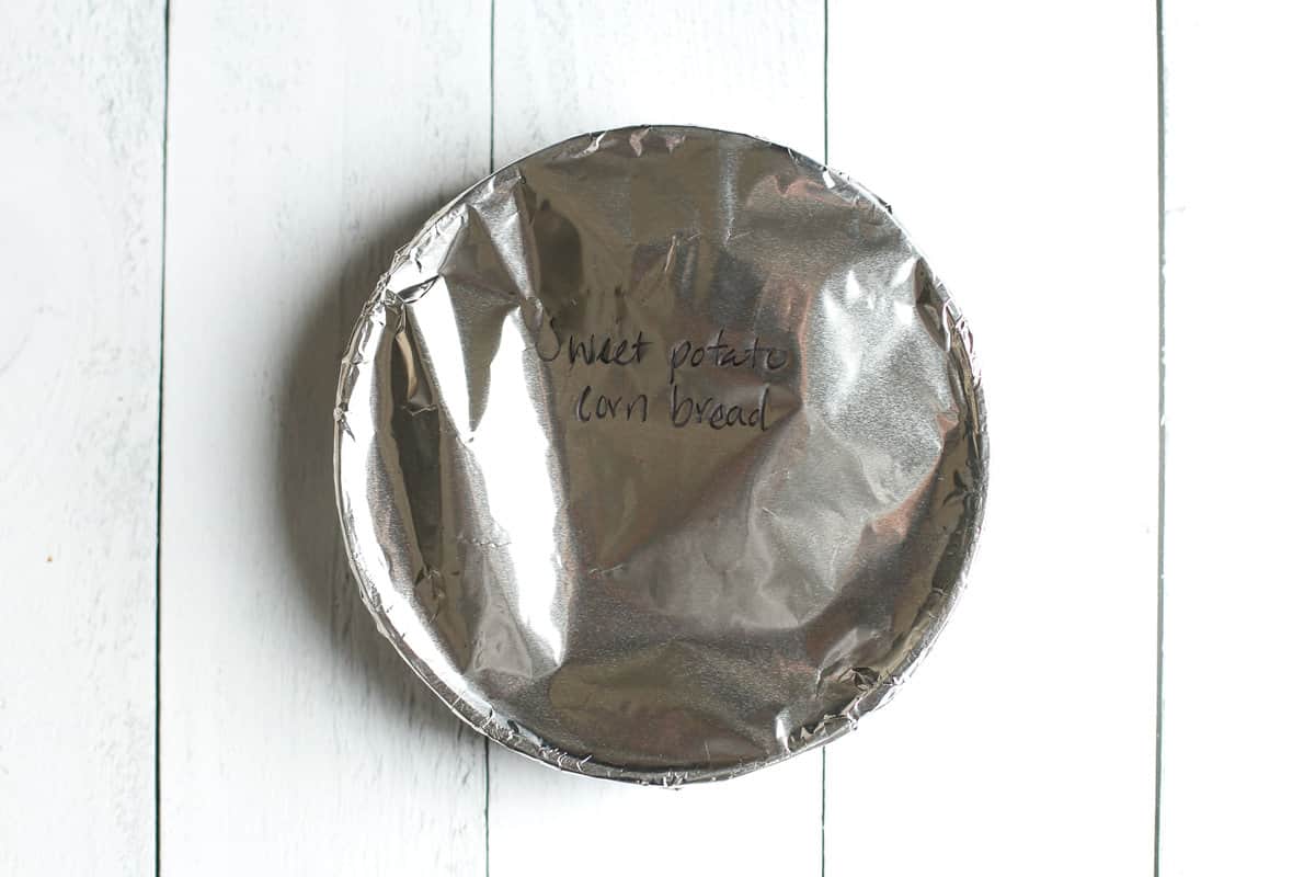 Round 9-inch pan covered with foil and labeled sweet potato cornbread.