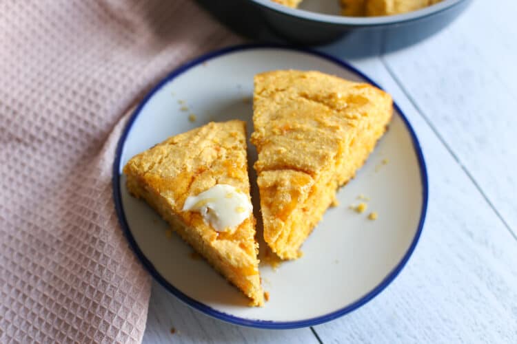 Sweet potato corn bread slices on a plate with butter.