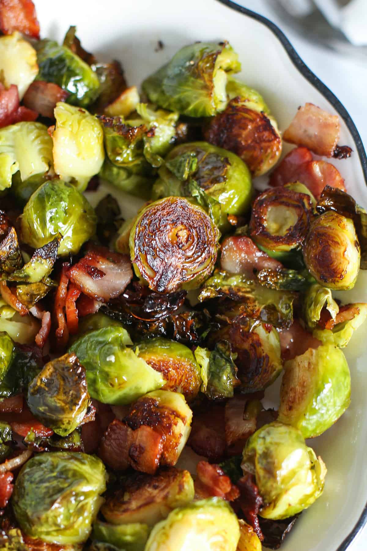 Roasted Brussels sprouts with bacon in a serving dish.