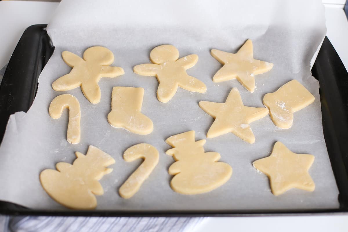 Cream cheese cookie dough cut out in Christmas shapes ready to go in the oven.