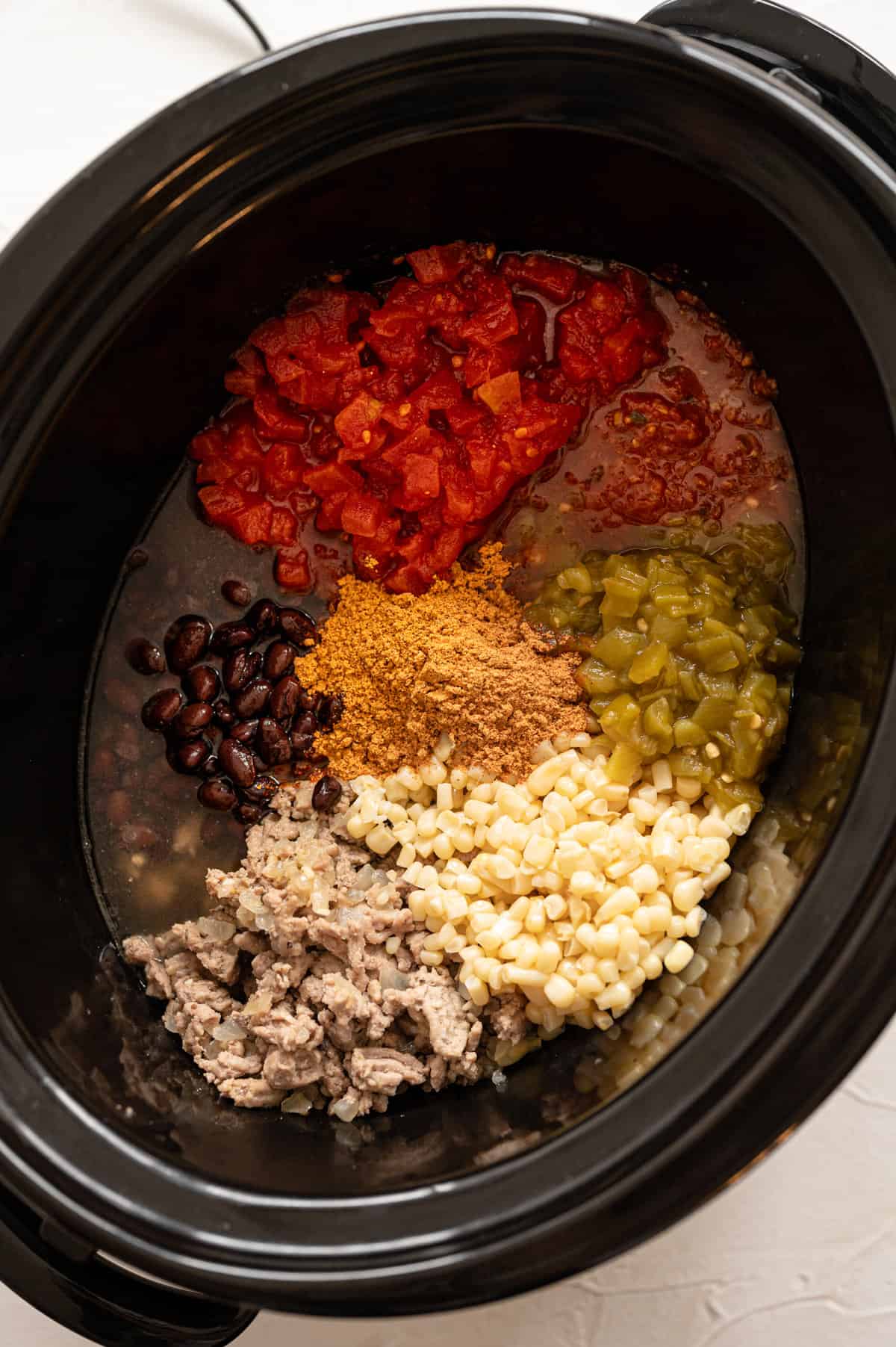 Taco soup ingredients ready to cook in a crock pot.