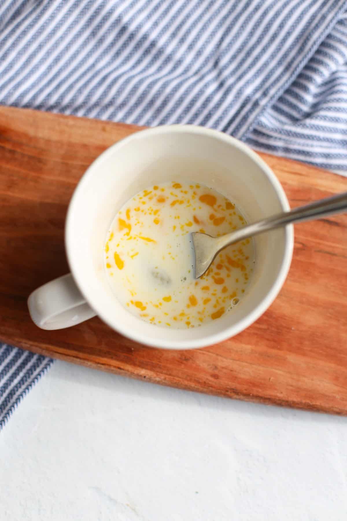 Milk and egg whisked together in a coffee mug.