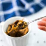 A spoonful of chocolate mug cake being lifted from the mug.