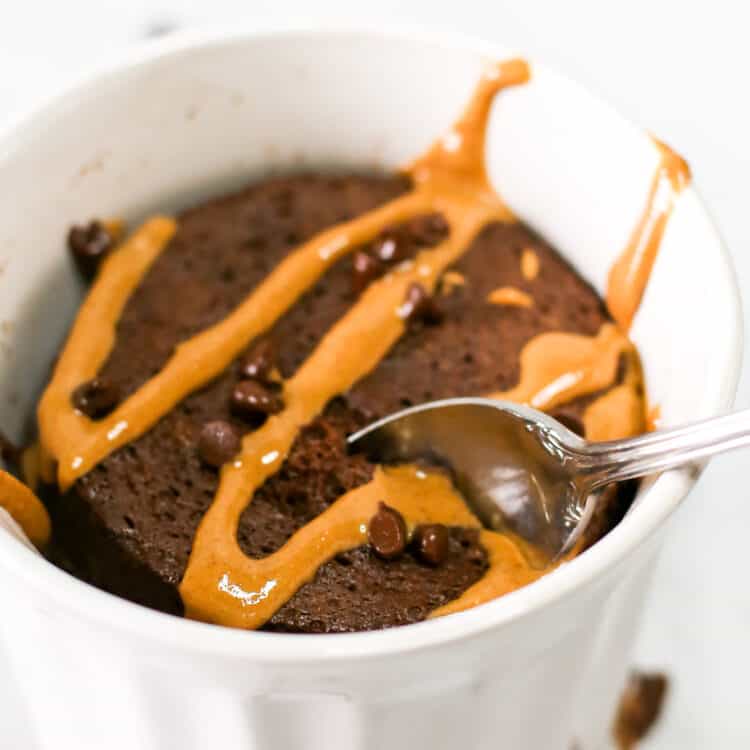 close up shot chocolate protein mug cake with peanut butter drizzle