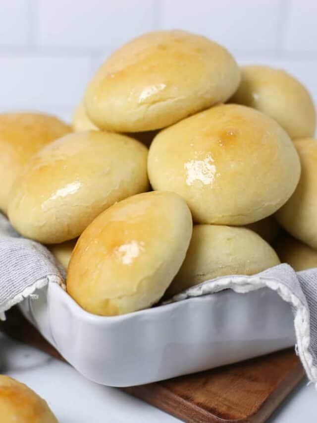 Bread machine dinner rolls piled up in a basket.