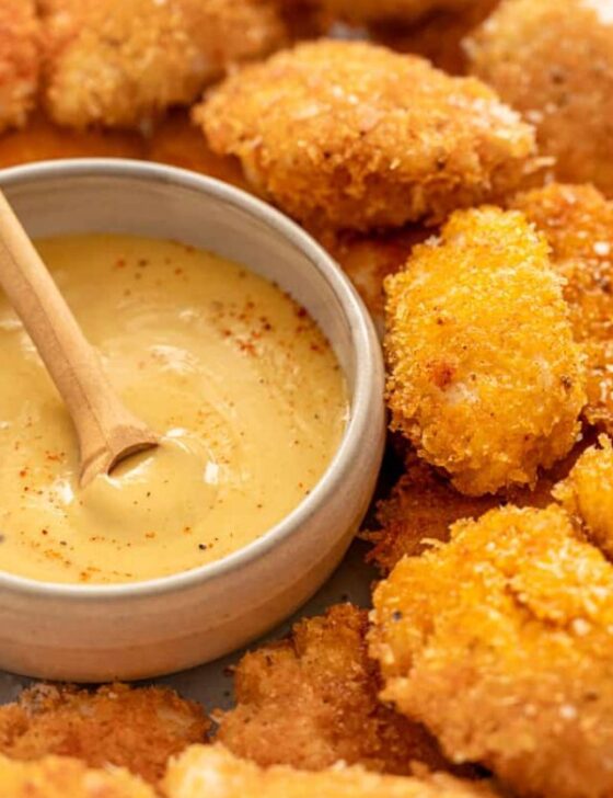 homemade chicken nuggets with honey mustard dipping sauce in a bowl