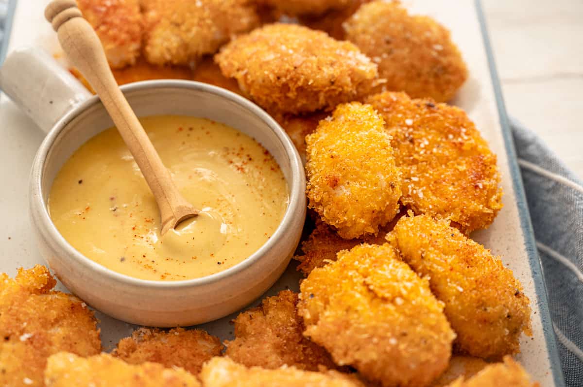 homemade chicken nuggets with honey mustard dipping sauce in a bowl