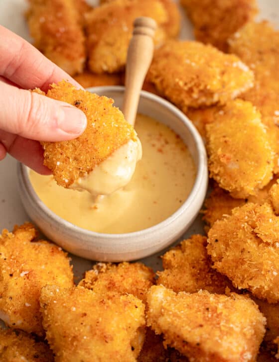 Chicken nuggets dipped in honey mustard dipping sauce.