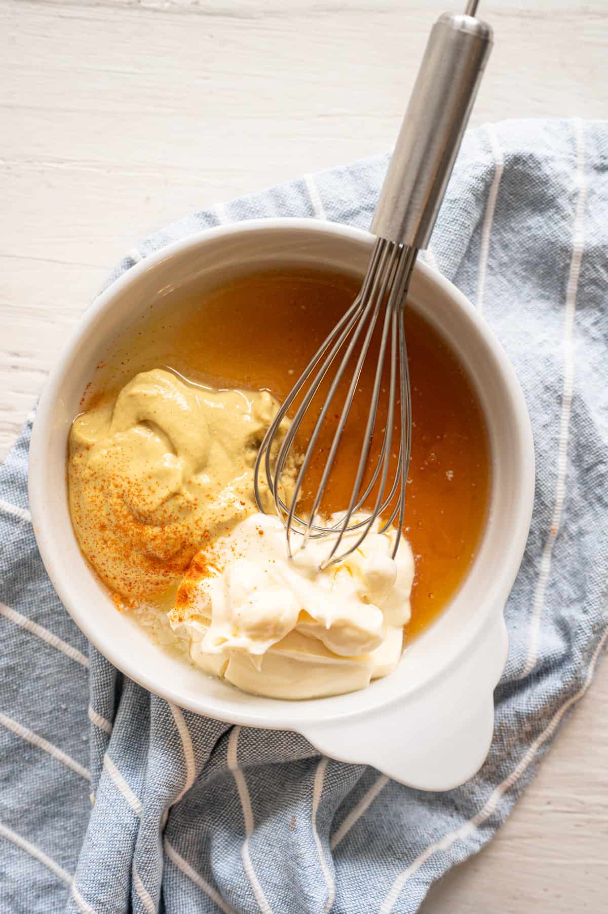 Process shot of mixing honey mustard dipping sauce with a whisk.