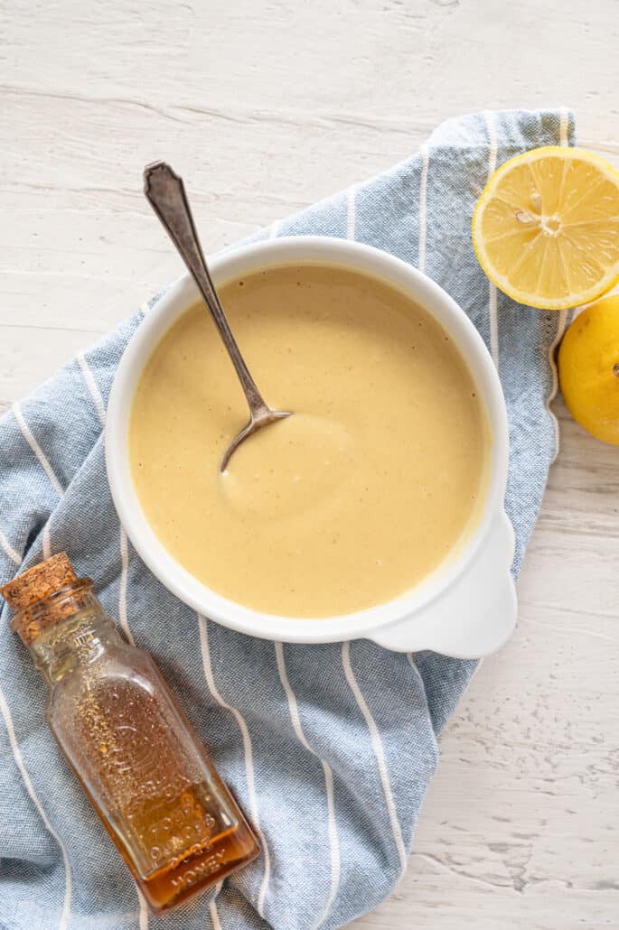 overhead shot of honey mustard dipping sauce in bowl with spoon