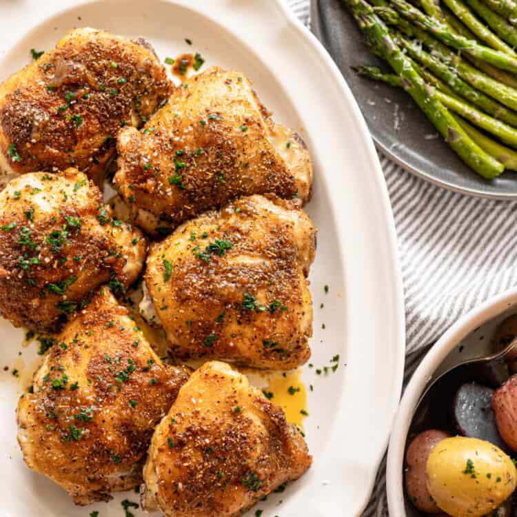 Italian Baked Chicken Thighs on a white platter.