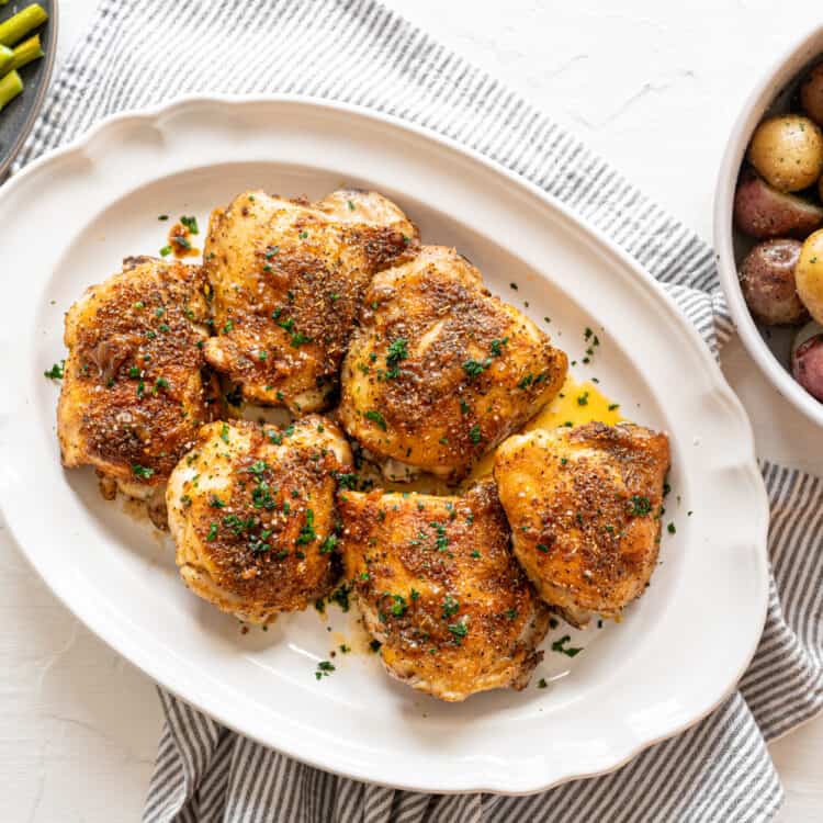 Italian Baked Chicken Thighs on a white platter.