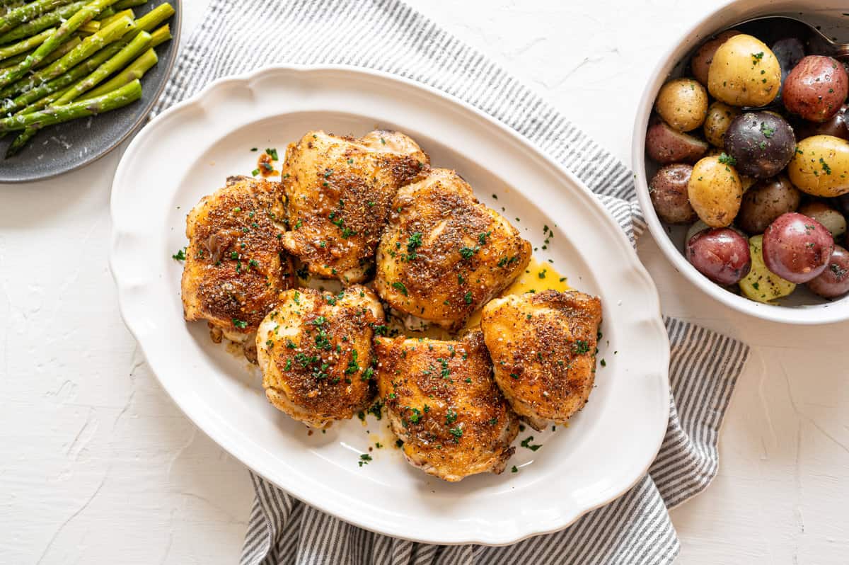 Italian Baked Chicken Thighs on a white platter.