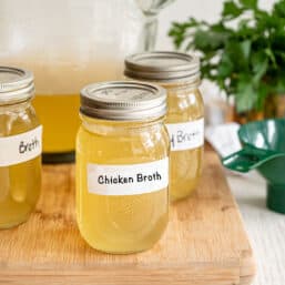 Full mason jars labeled chicken broth.
