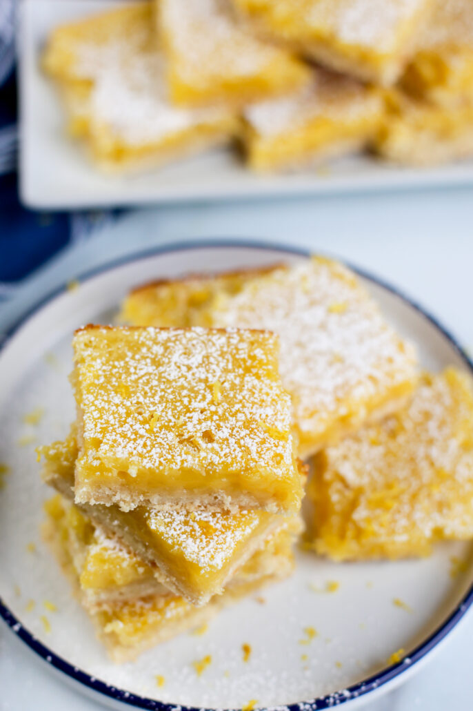 lemon bars stacked on a plate