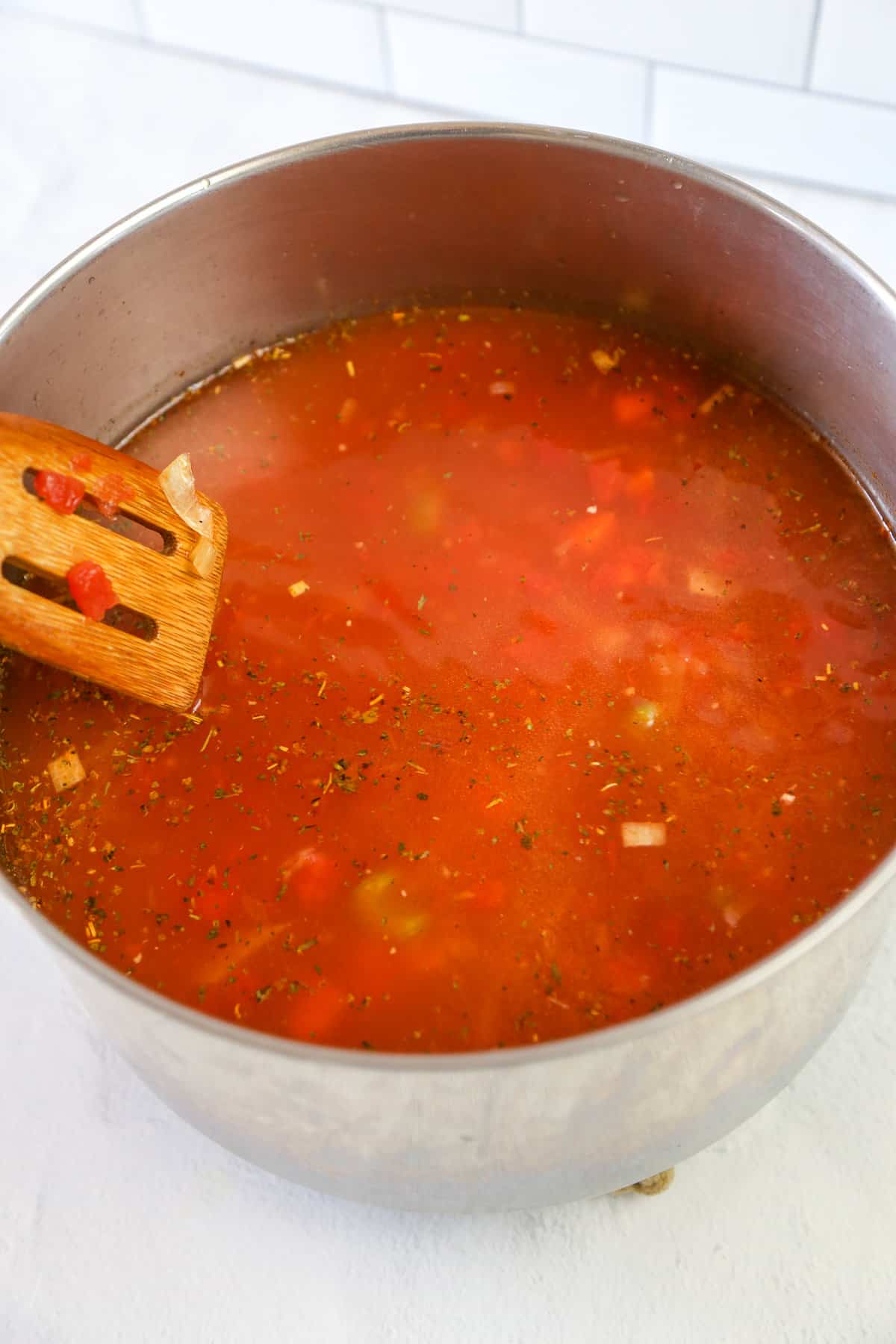 Sauteed veggies, broth, and canned tomatoes in a stock pot.