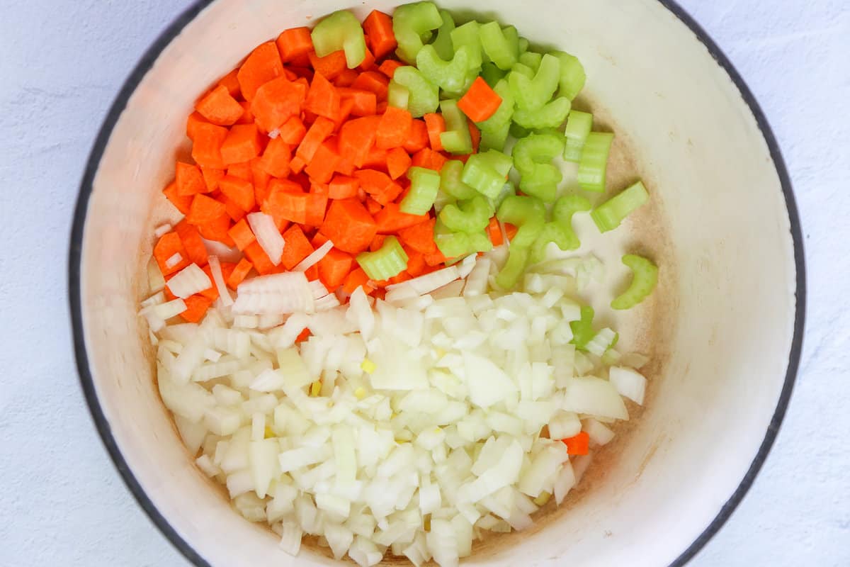 Chopped carrots, celery, and onion in a pot ready to be sauteed.