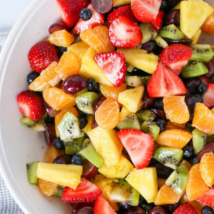 Fruit salad in a white serving bowl.