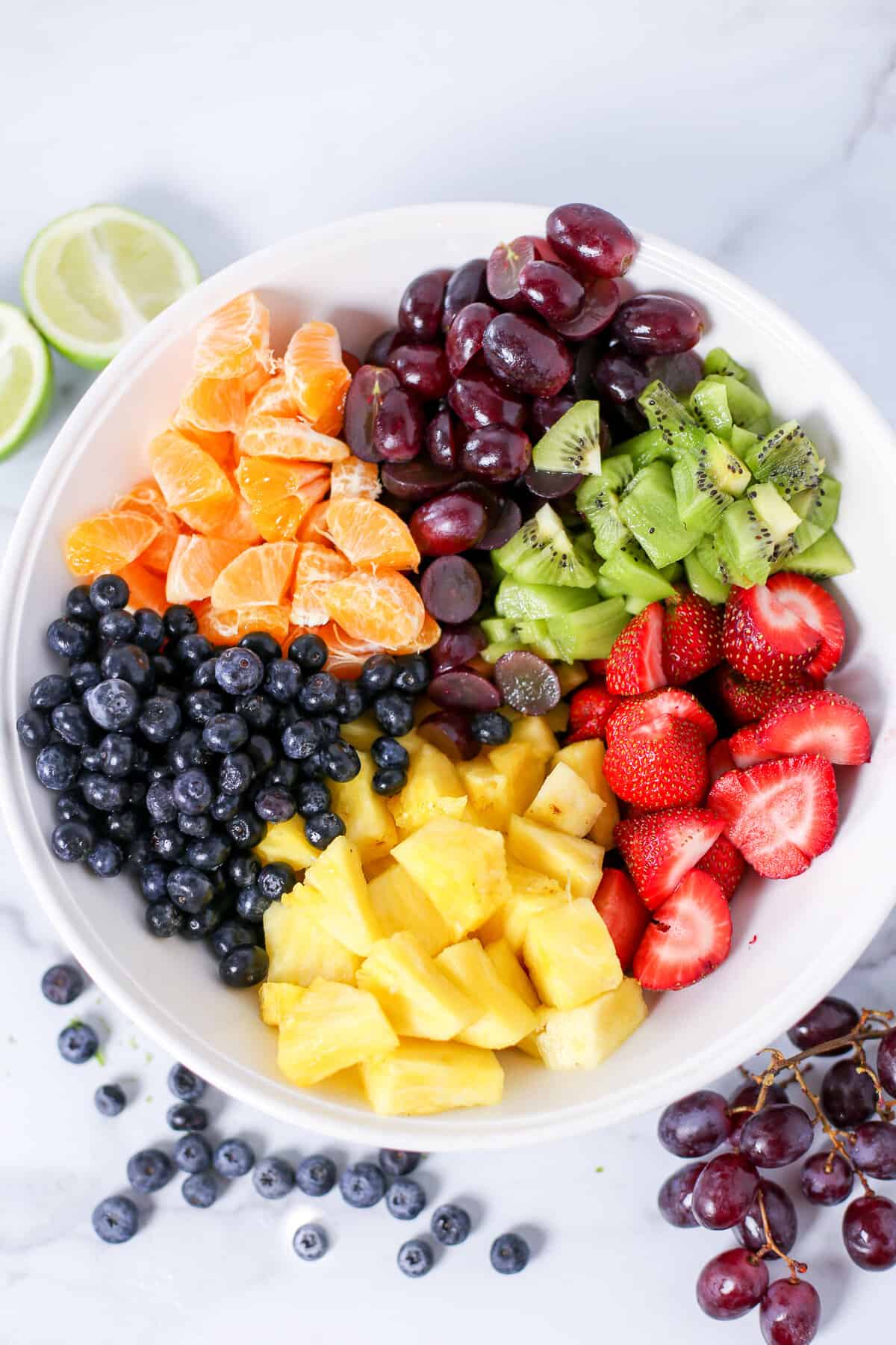 Chopped fruit grouped together in a white bowl.