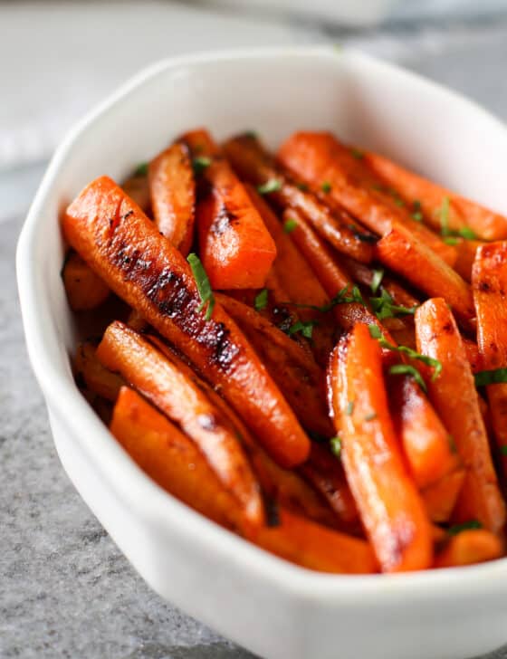 Maple roasted carrots in a white bowl.