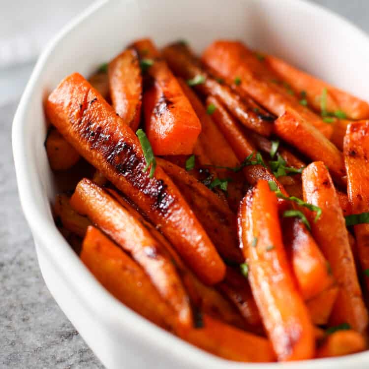 Maple roasted carrots in a white bowl.
