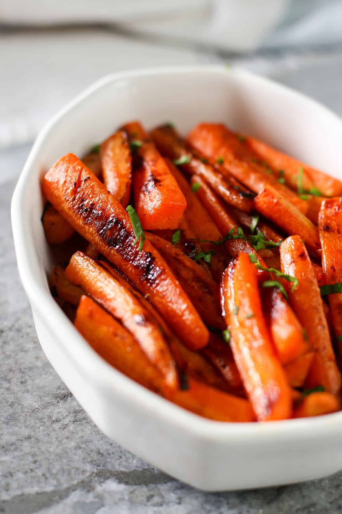 Maple roasted carrots in a white bowl.