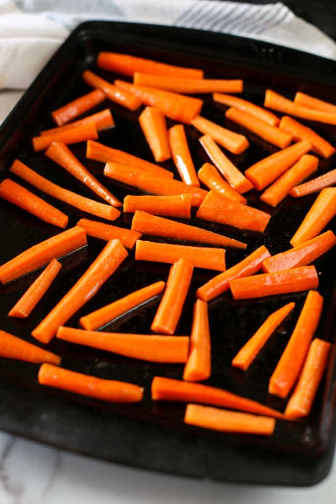 Raw carrots placed on roasting pan