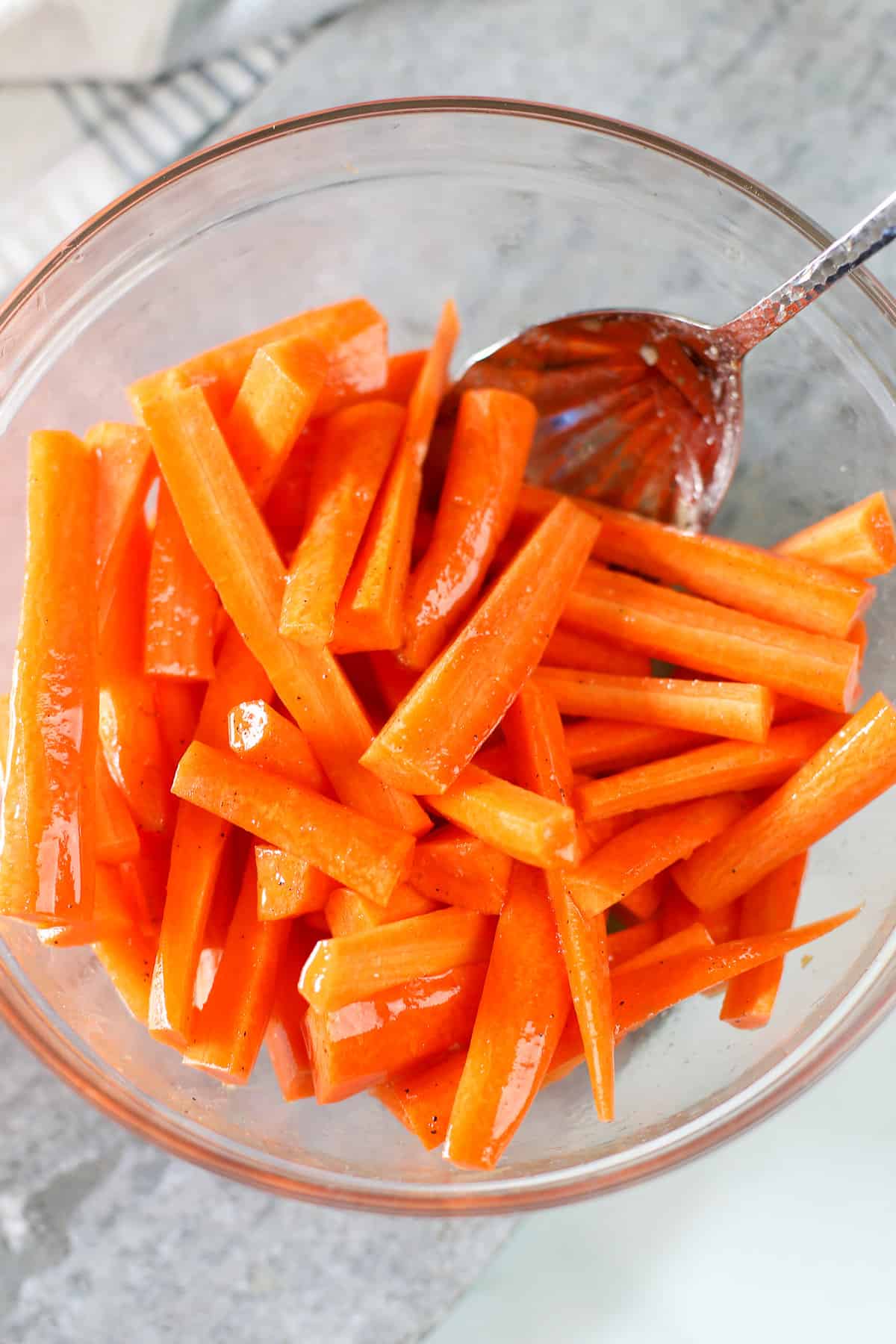 Tossing sliced carrots in maple syrup and butter