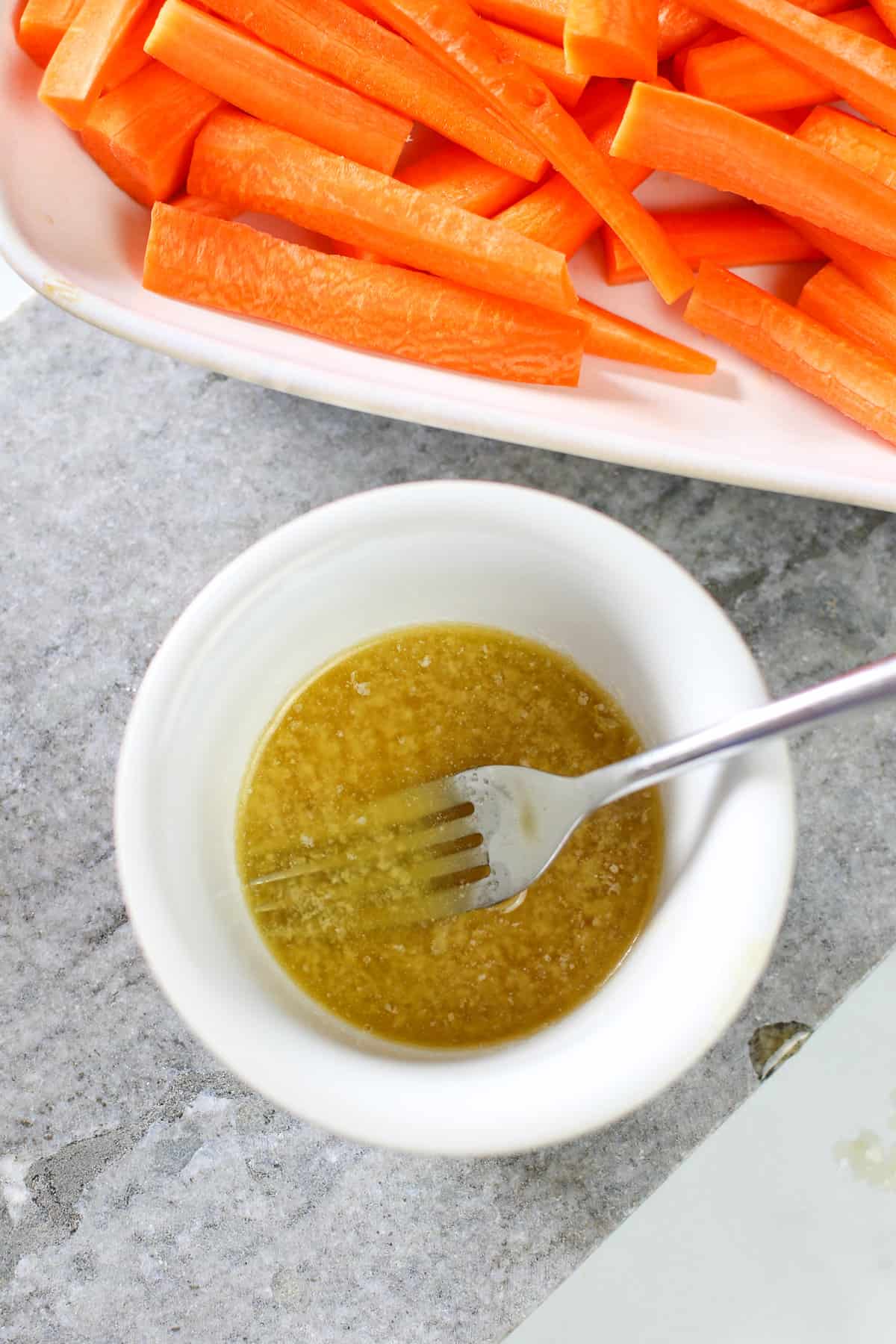 Melted butter and maple syrup in a white bowl.