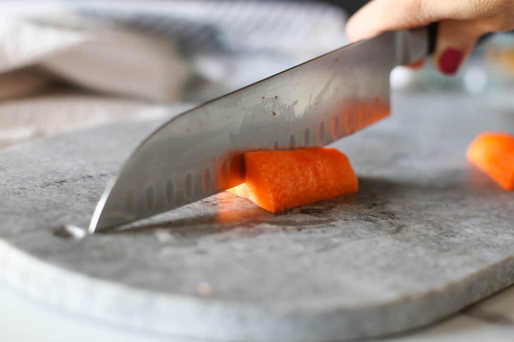 A knife slicing into a carrot