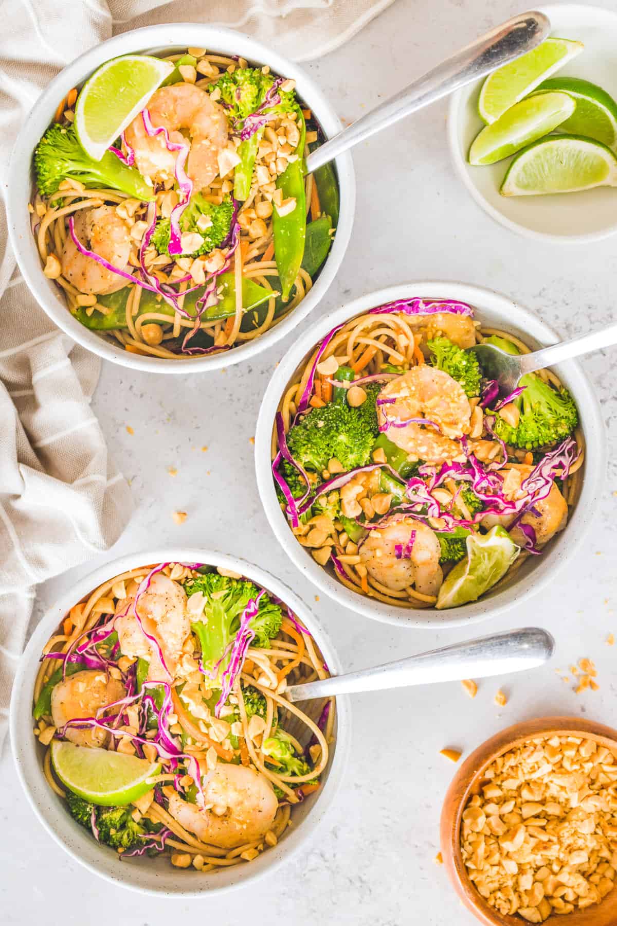 Three bowls of shrimp curry with forks in them.