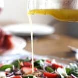 Spinach salad on table with Lemon-Honey Vinaigrette.