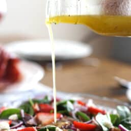 Spinach salad on table with Lemon-Honey Vinaigrette.