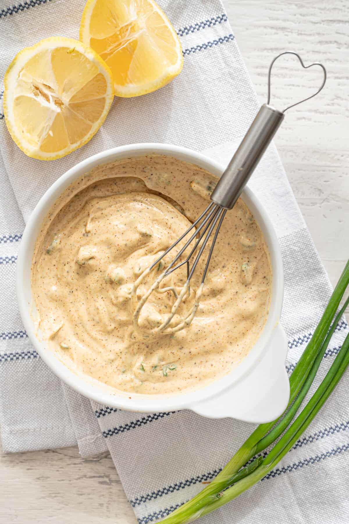 Whisking easy Cajun remoulade sauce ingredients together in a bowl.