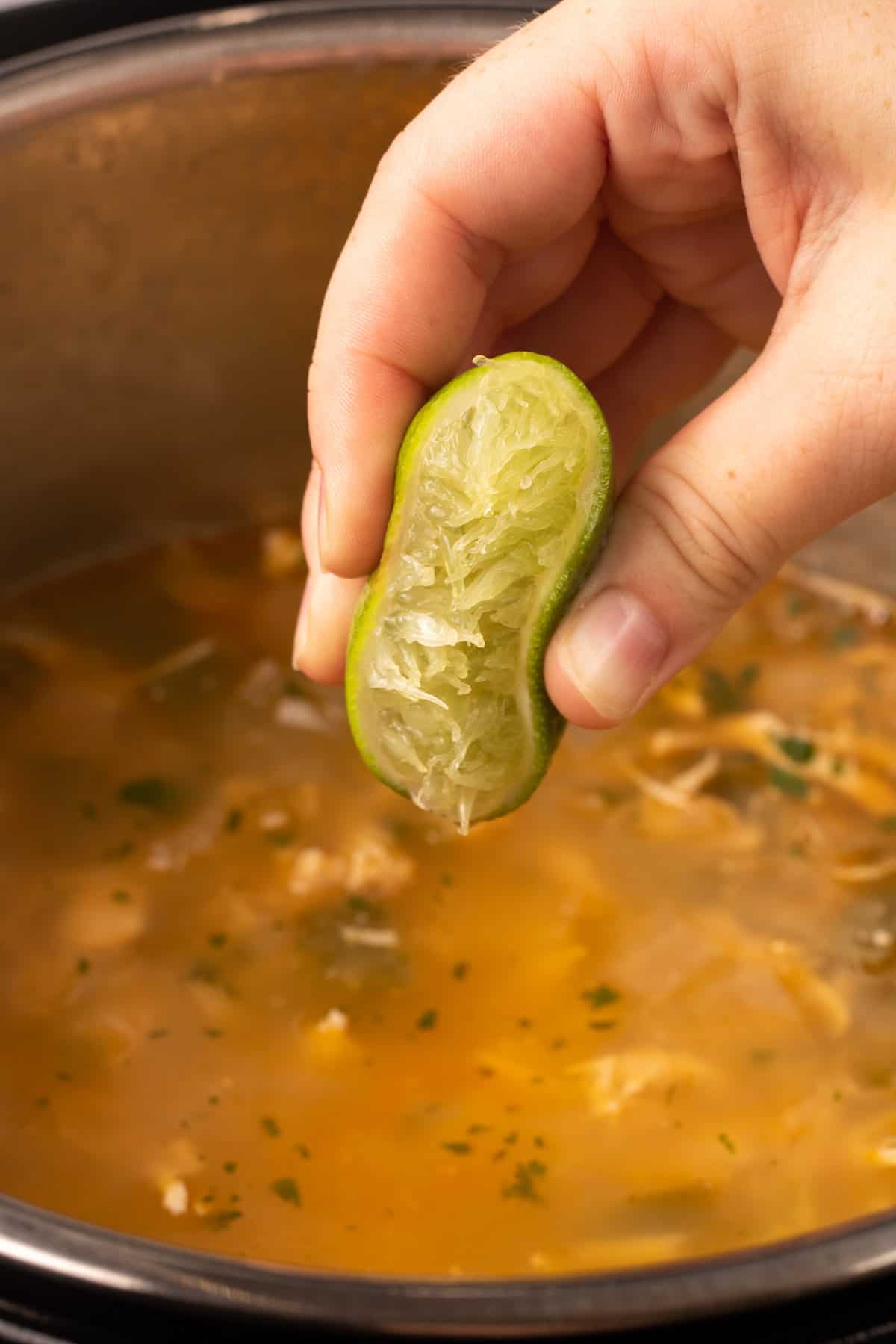 lime being squeezed into white chicken chili