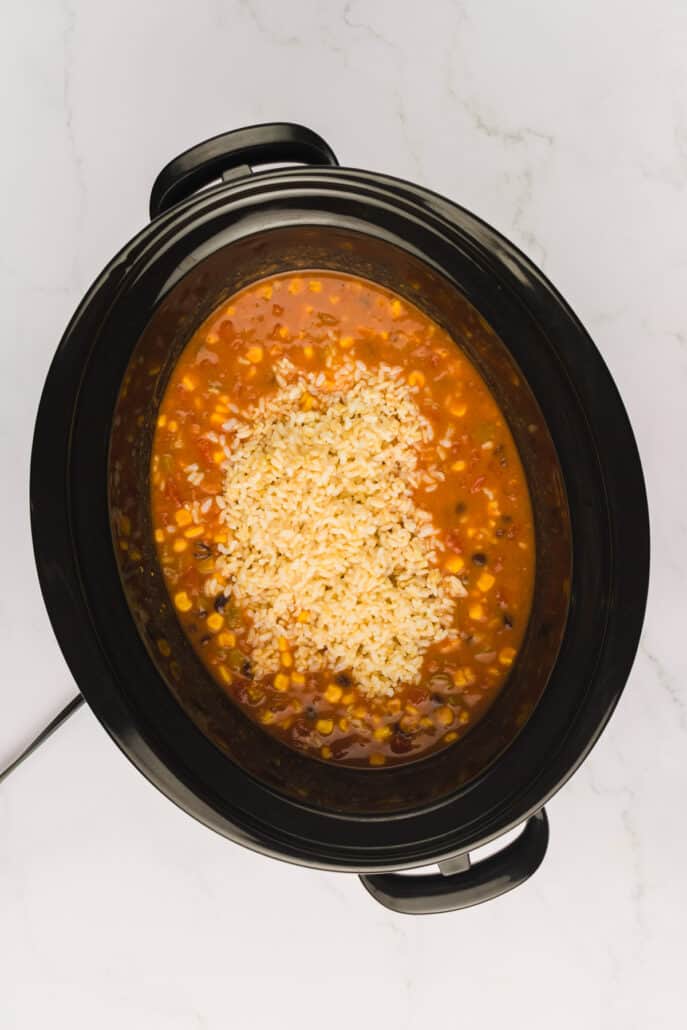 Adding rice into the crock pot tortilla soup