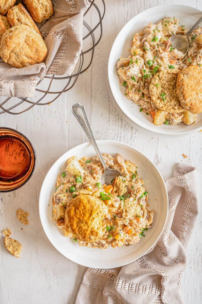 chicken pot pie mixture in a bowls with a whole wheat biscuits on top