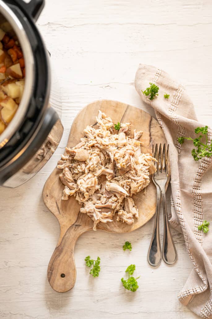 shredded chicken thighs next to Instant pot