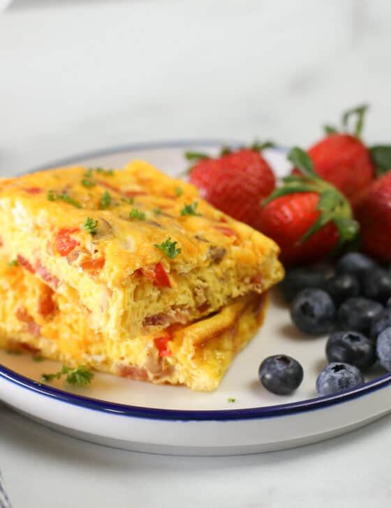 baked omelette on a plate with strawberries and blueberries