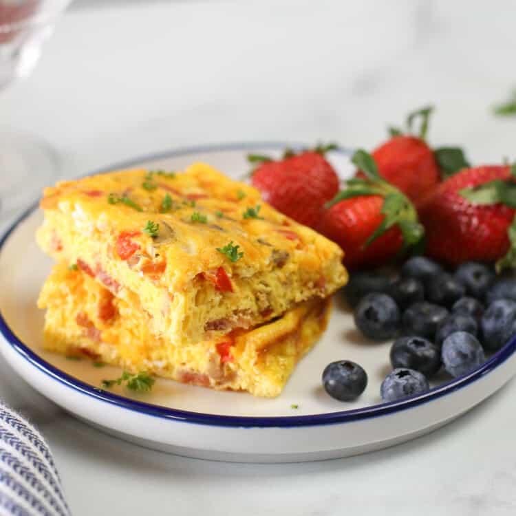 baked omelette on a plate with strawberries and blueberries