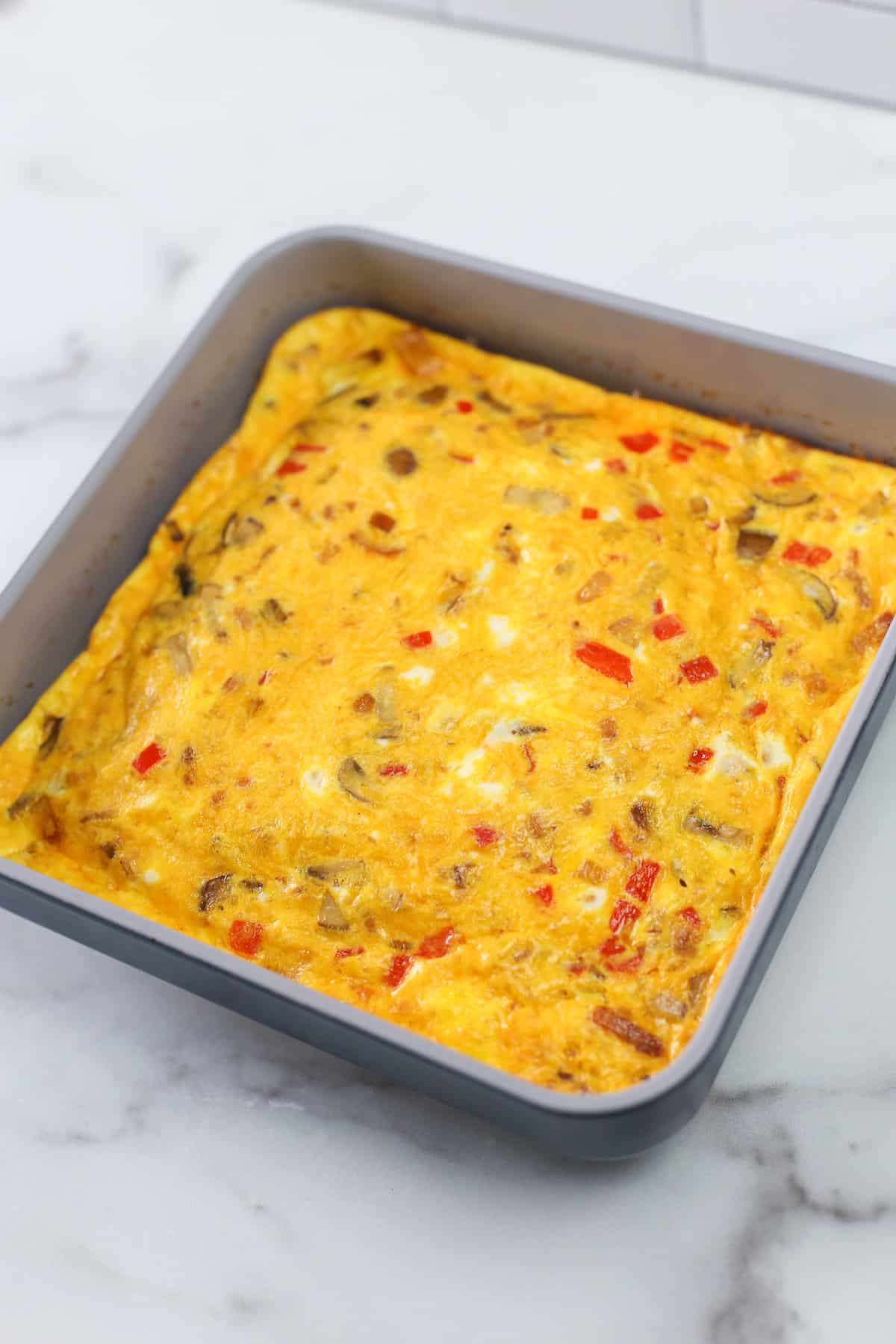 Baked omelette in baking pan cooling on the countertop.