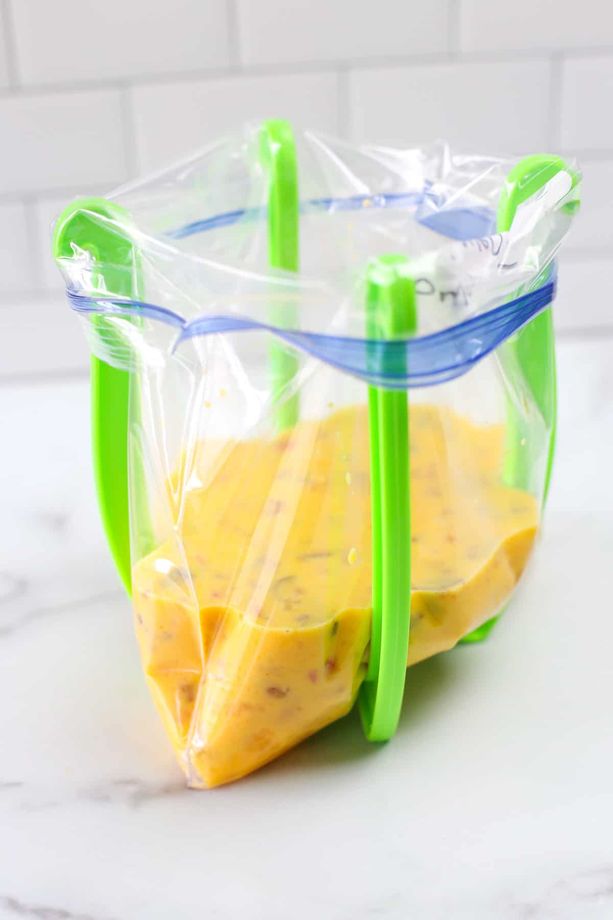 Baked omelette mixture in a freezer bag that is in a freezer bag stand.