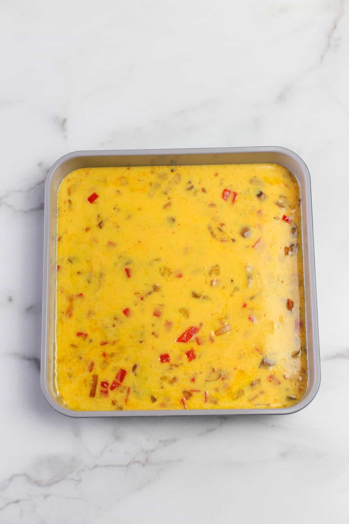 Uncooked baked omelette in a square pan ready to go in the oven.