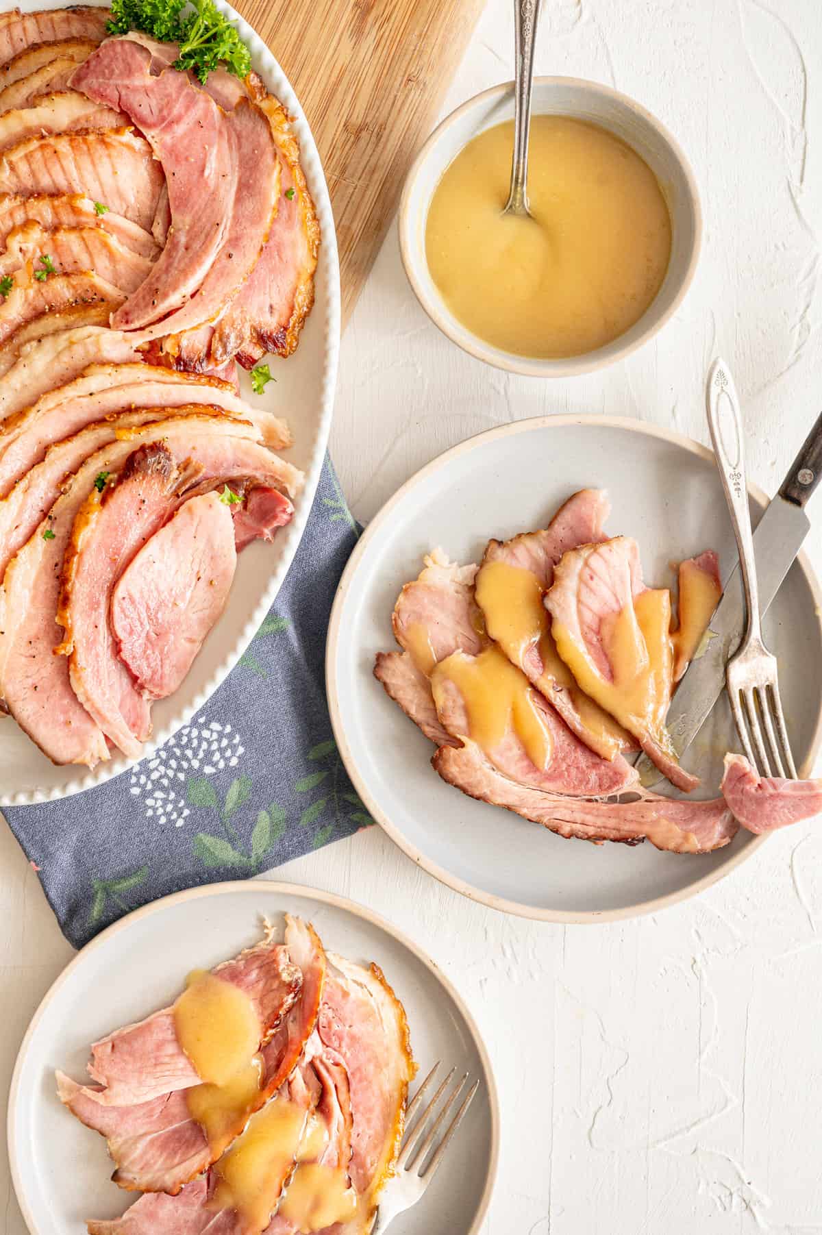 Spiral sliced ham with pineapple sauce drizzled over it on a plate.