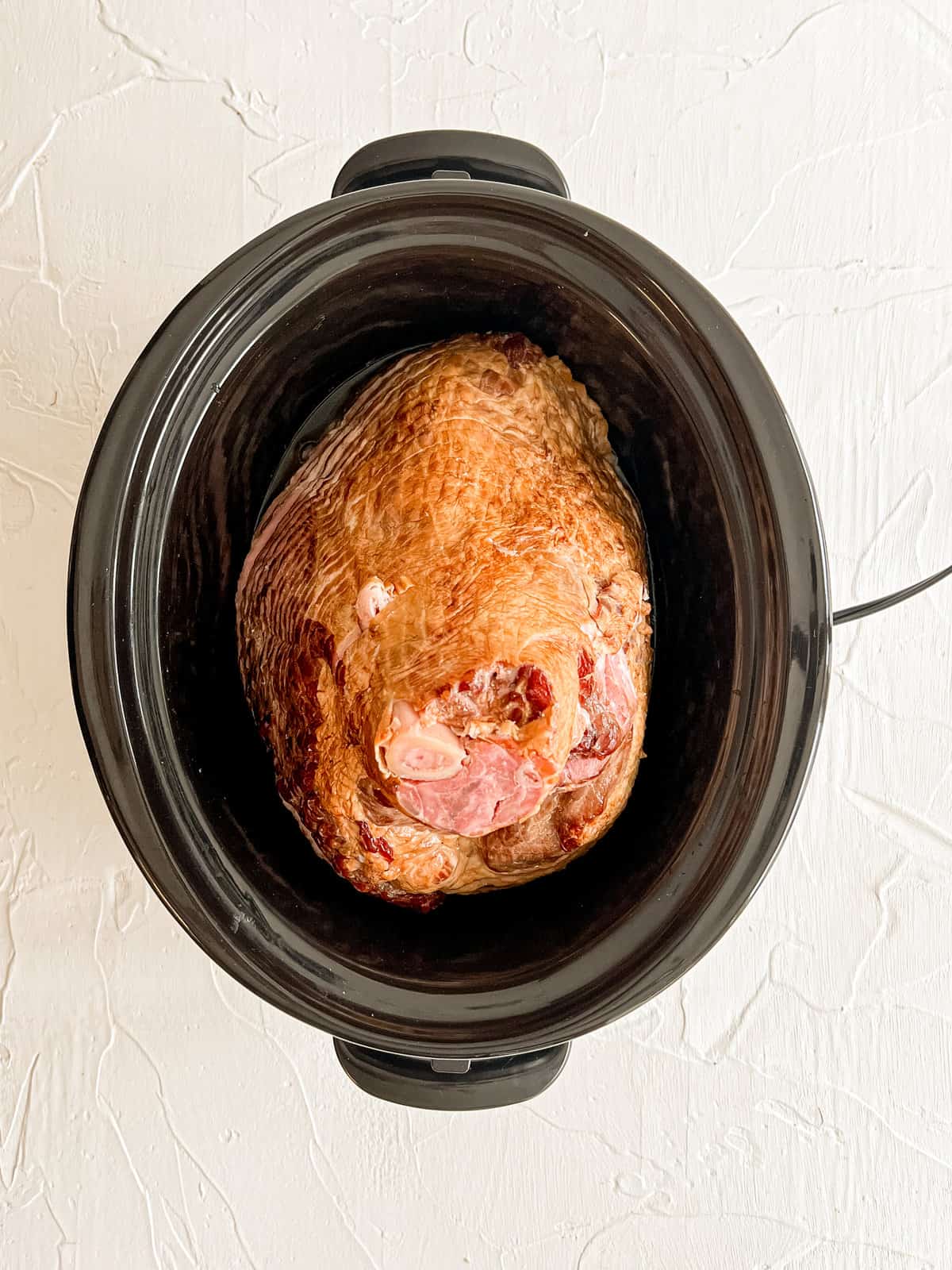 A bone-in spiral sliced ham in a crockpot.