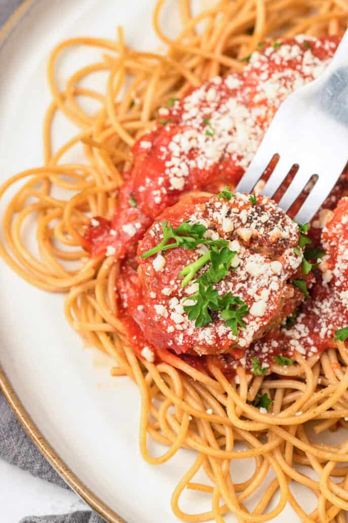 fork picking up a turkey meatball and spaghetti