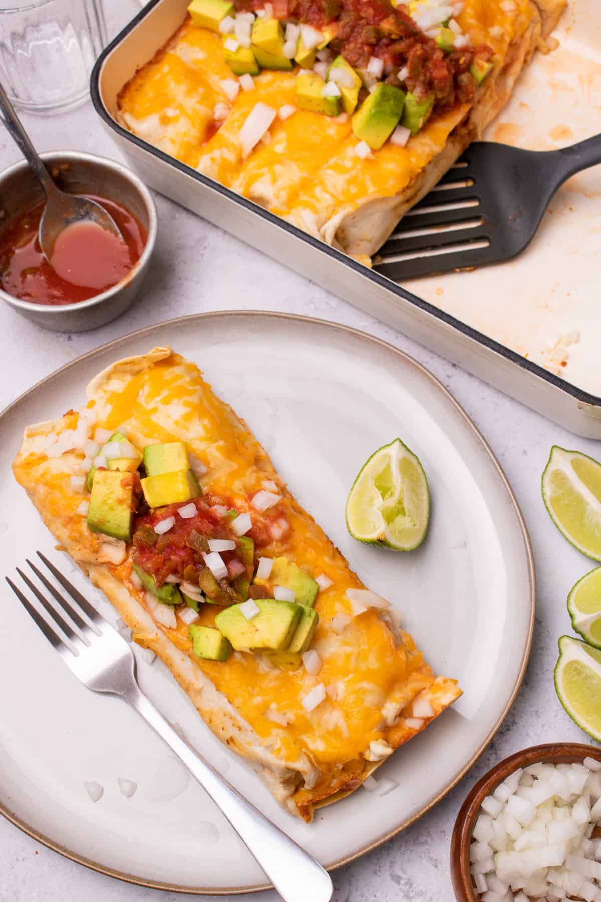 Chicken fajita casserole served on a plate with salsa and avocado on top.