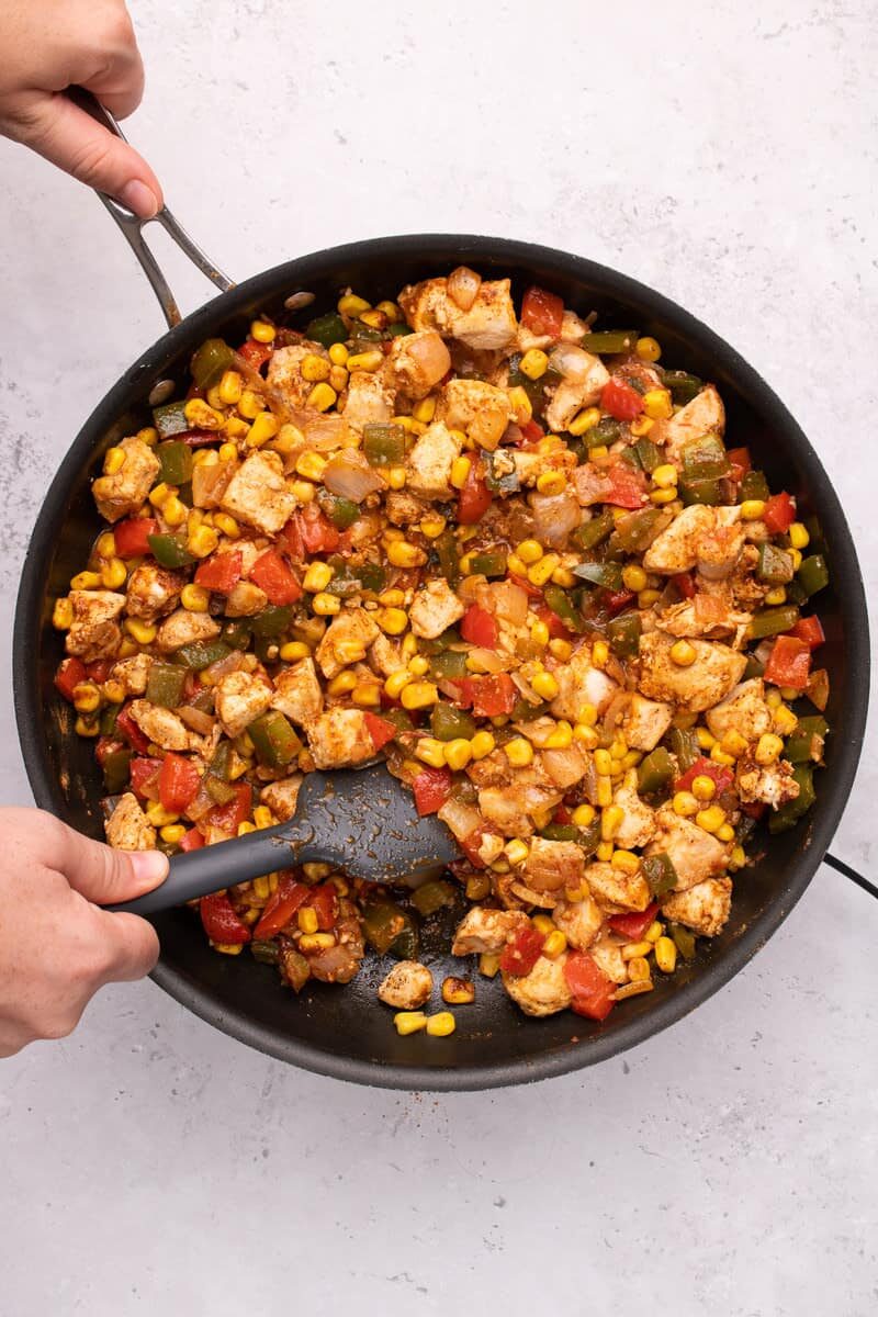 sautéeing veggies and chicken in a skillet