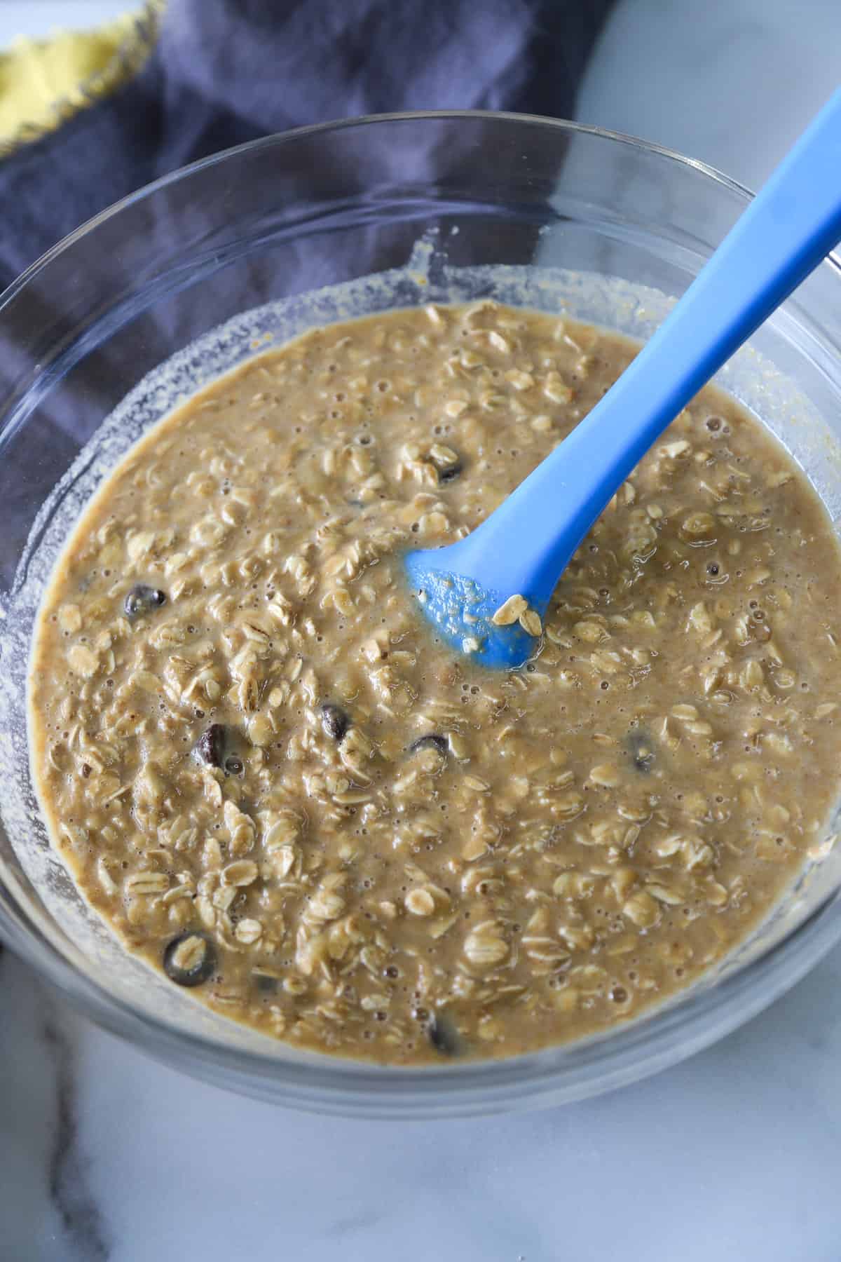 Batter for banana baked oatmeal in a large glass mixing bowl.