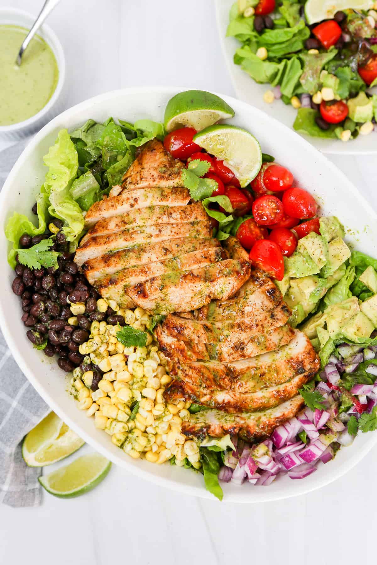 Southwest Chicken Salad on a big platter with Cilantro Lime Dressing in a bowl on the side.